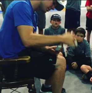 Carey Price tapes his stick at a youth hockey goalie camp as young players watch closely.
