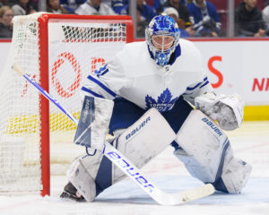 Freddie Andersen in Toronto Maple Leafs white pads in butterfly stance, tracking a shot in front of the crease