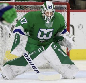 James Reimer in Hartford Whalers throwback green jersey, set in butterfly stance, wearing Bauer pads and gloves, in crease...