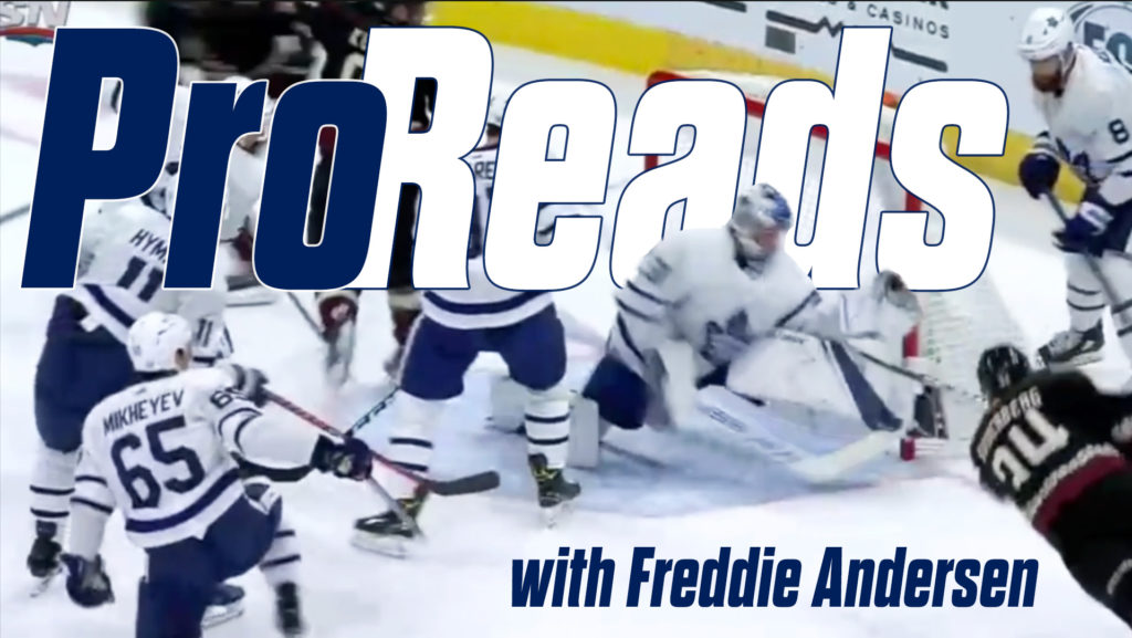 Freddie Andersen in Maple Leafs gear making a save amid traffic during a scramble in front of the net