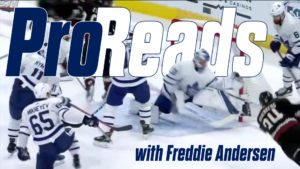Freddie Andersen in Maple Leafs gear making a save amid traffic during a scramble in front of the net