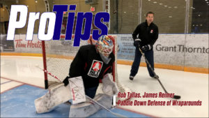 James Reimer in butterfly paddle-down position defending a wraparound with Rob Tallas coaching on ice behind him