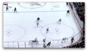 Frederik Andersen in crease facing multiple attackers in a 3-on-2 rush scenario, aerial view of NHL ice