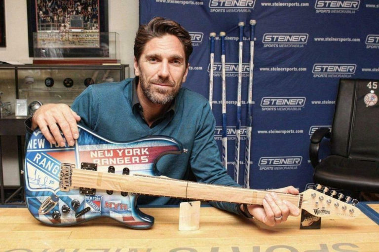Henrik Lundqvist poses with a signed New York Rangers-themed electric guitar at a Steiner Sports memorabilia event