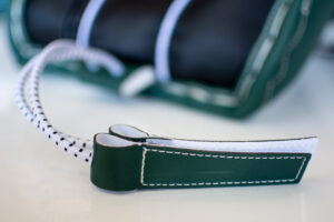Close-up of CCM AXIS goalie pad boot channel with green leather toe tie and bungee lace attachment detail