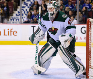 Minnesota Wild goalie in white away pads and Bauer gear sets in butterfly stance at Rogers Arena, March 2018