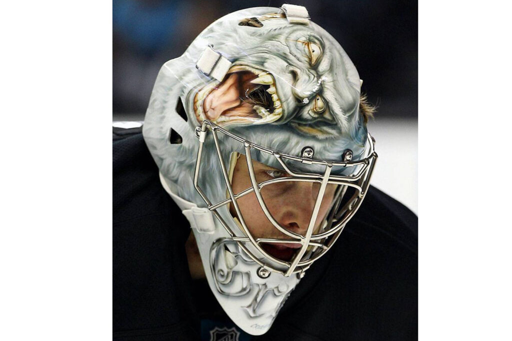 Thomas Greiss goalie mask featuring a snarling monster or creature design with detailed airbrush artwork