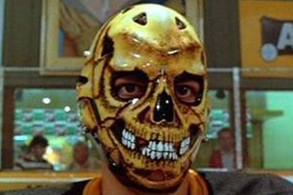 Goalie wearing a vintage skull-themed Halloween horror goalie mask, featured in article about scary goalie masks