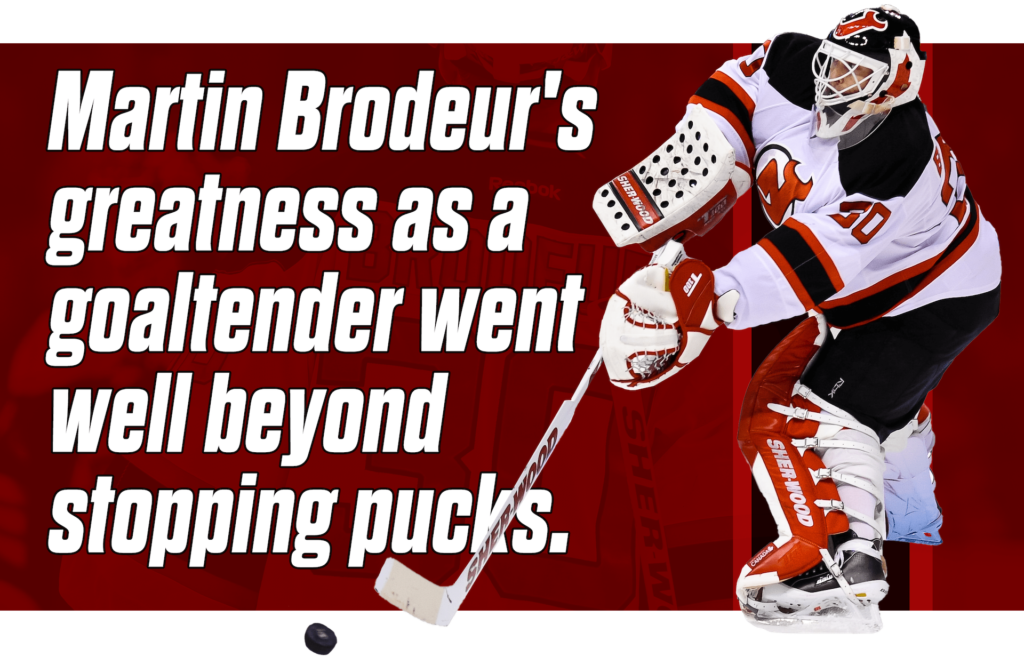 Martin Brodeur in New Jersey Devils white jersey handles the puck behind the net with his blocker hand