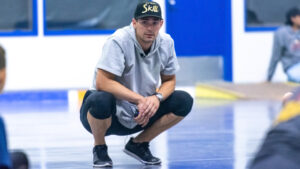 Carey Price crouches low on a gym floor during an off-ice goalie training session wearing a Skill cap and athletic wear