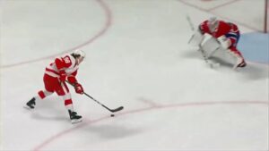 Carey Price retreats toward his net in butterfly stance as a Red Wings skater approaches on a breakaway