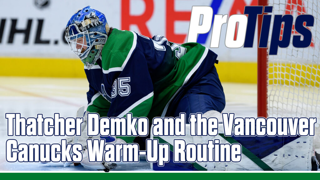 Thatcher Demko in Vancouver Canucks gear making a blocker save in a low butterfly during pre-game warm-up