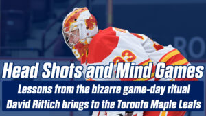 Calgary Flames goalie David Rittich in butterfly stance wearing red and yellow pads and jersey