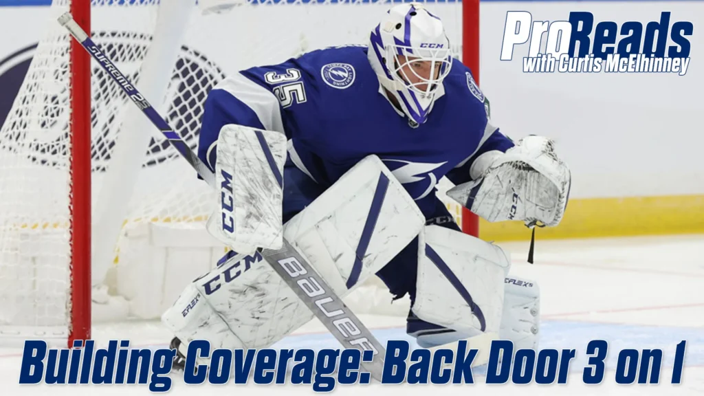 Tampa Bay Lightning goalie Curtis McElhinney in butterfly stance tracking a 3-on-1 rush, glove raised in ready position
