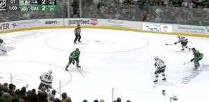 Braden Holtby tracking a 3-on-1 rush in Dallas Stars arena, set in butterfly-ready stance protecting the net.
