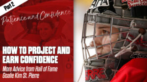 Hall of Fame goalie Kim St. Pierre in close-up portrait wearing red jersey and cage mask, projecting focused confidence