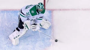 Ben Bishop overhead view handling puck in crease wearing Dallas Stars white CCM gear