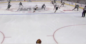 Ryan Miller tracks a rush from his crease, holding edges in butterfly stance as players converge on a 3-on-2 odd-man rush.