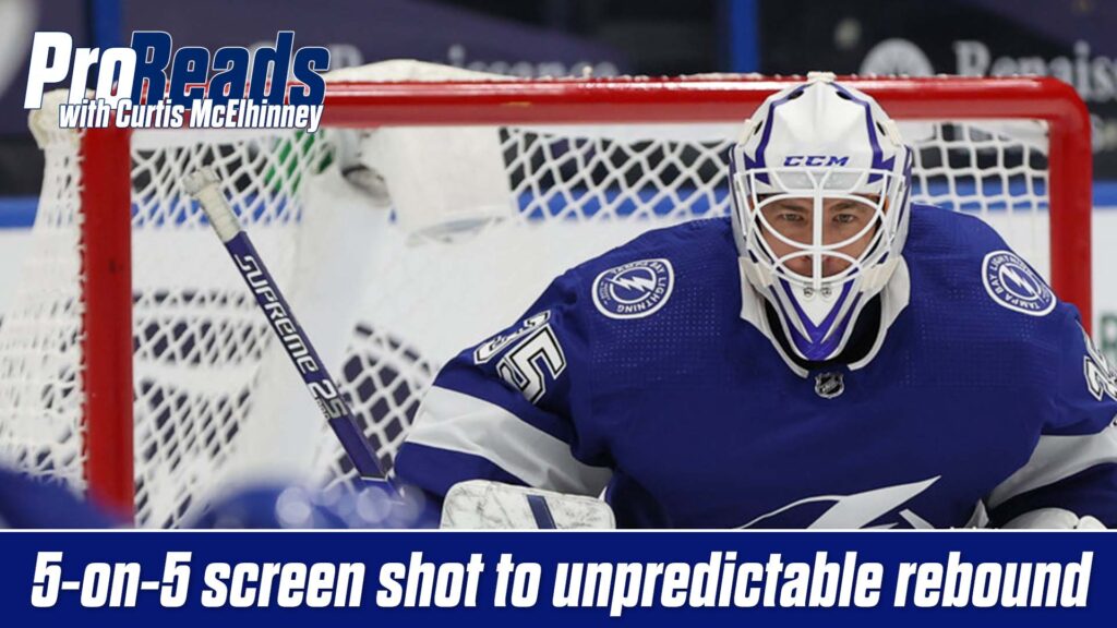 Curtis McElhinney in Tampa Bay Lightning gear tracking a screen shot in his butterfly stance, CCM helmet visible