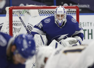 Tampa Bay Lightning goaltender Curtis McElhinney in crouch stance tracking play in blue Lightning gear during Panthers gam...