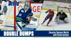 Canucks goalie Spencer Martin in butterfly position during double dump drill, with Curtis Sanford demonstrating technique ...