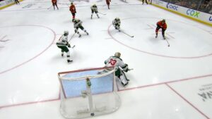 Cam Talbot in Minnesota Wild gear set in crease during penalty kill as opposing forwards create a screen in front of the net.
