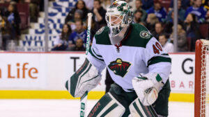 Minnesota Wild goalie Devan Dubnyk in ready stance, tracking play in green and white pads at Rogers Arena