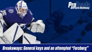 Tampa Bay Lightning goalie Curtis McElhinney in butterfly stance tracking a breakaway, wearing white pads and #35 jersey