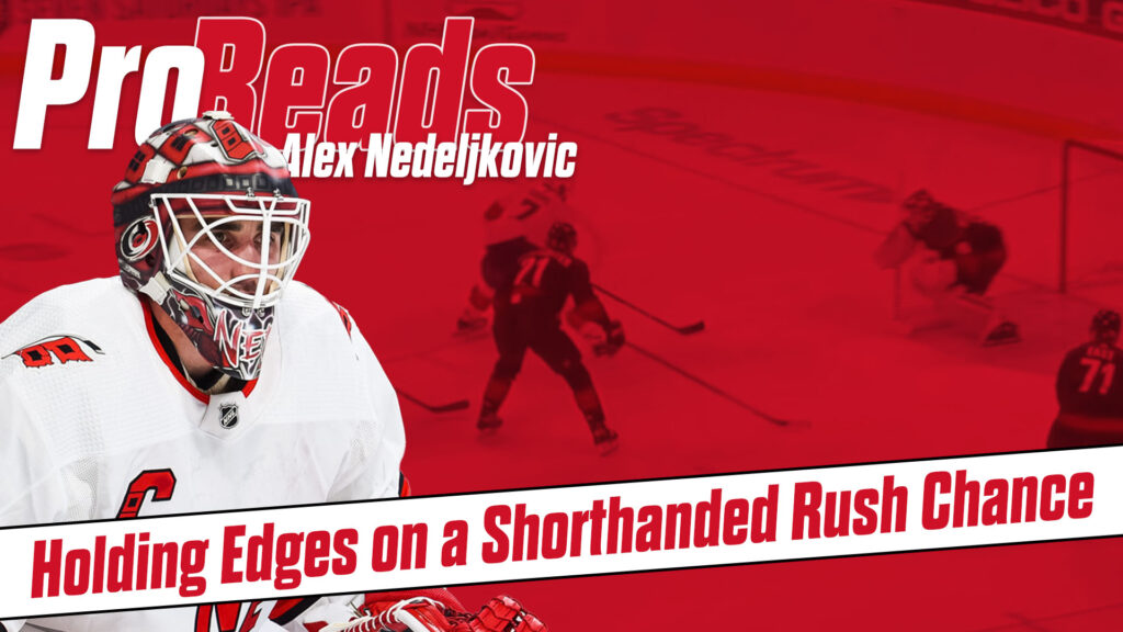 Alex Nedeljkovic in white Carolina Hurricanes gear holding edges in butterfly stance during a shorthanded rush chance