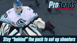 Seattle Kraken goalie Joey Daccord in butterfly stance wearing teal mask and white jersey during a Pro Reads instructional...