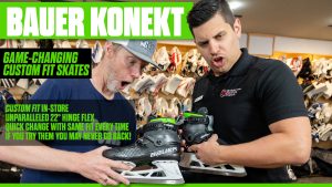 Two men examining Bauer Konekt custom-fit goalie skates in a hockey equipment store