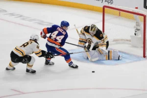 Linus Ullmark makes a blocker save for the Bruins as Islanders forward Jean-Gabriel Pageau drives to the net