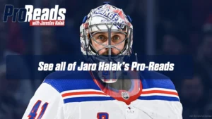 Jaroslav Halak in New York Rangers white jersey and helmet, focused in butterfly stance, tracking play during an NHL game.