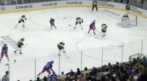 Linus Ullmark in Rangers blue crouches in butterfly stance as players drive the net during an NHL game
