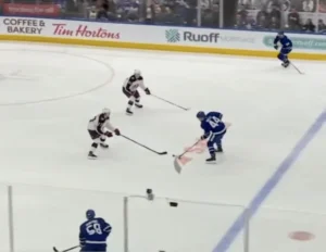 Jet Greaves shuffles across crease to defend backdoor pass on a rush, Toronto Maple Leafs arena, blue pads visible