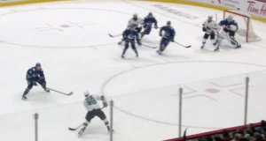 Thatcher Demko hugging his post as Canucks defenders battle a screen in front during a crowded crease situation
