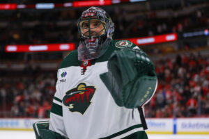 Marc-Andre Fleury in Minnesota Wild white jersey and painted goalie mask looks on during NHL game at United Center