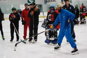 Blues goalie coach David Alexander leads on-ice drill at goaltending convention, demonstrating technique to group of goali...