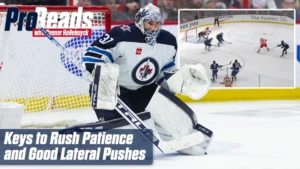 Connor Hellebuyck in Winnipeg Jets gear set in butterfly stance tracking a rush, demonstrating patience and lateral push t...
