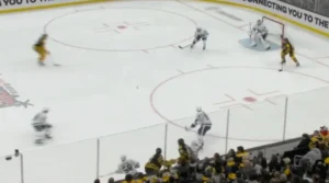 Matt Murray in Bruins gear squares up during a 2-on-1 down low, tracking the puck as two attackers converge near the crease.