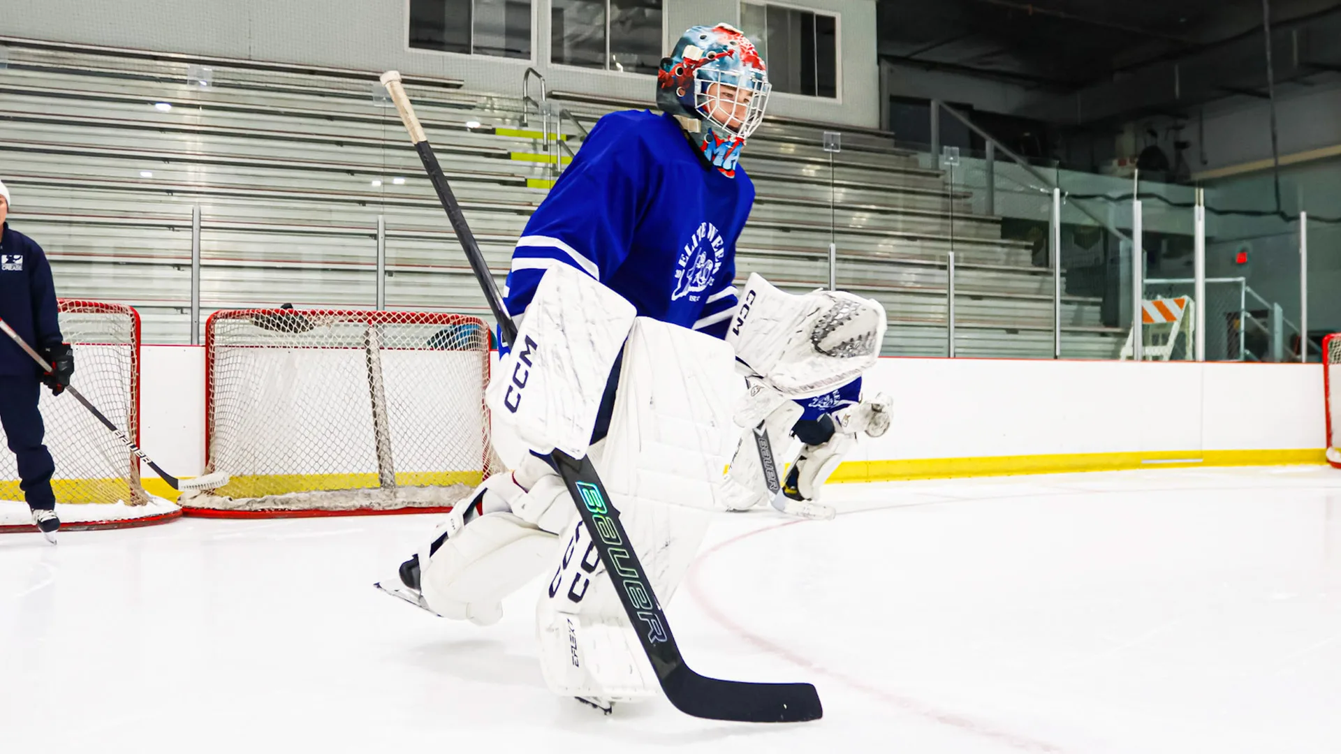 Goalie in Maple Leafs-style blue and white gear stands ready in butterfly stance during Connecticut Crease on-ice training...