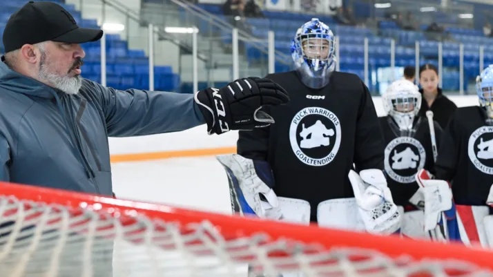 PWGoaltending coach instructs a masked goalie during on-ice training session in Oshawa, Ontario