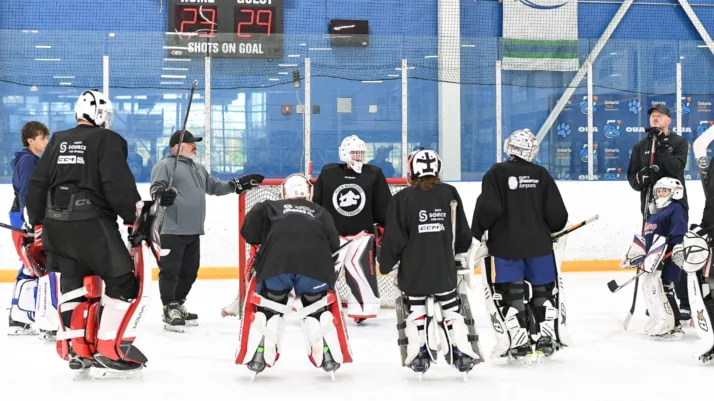 PWGoaltending coach addresses group of goalies in full gear during on-ice training session in Oshawa, ON