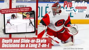 Hurricanes goalie Frederik Andersen in red set position tracking a 2-on-1 rush, wearing Carey Price-style mask