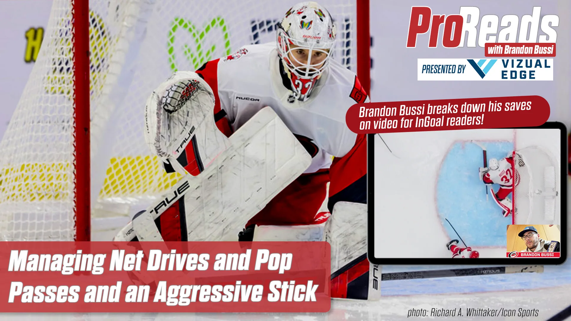 Brandon Bussi makes a paddle-down save in white Detroit Red Wings gear, aggressively challenging with his stick extended.