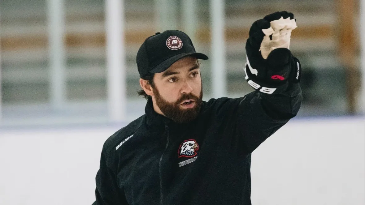Goalie coach Travis Hoy demonstrates technique on ice during a training session in Vernon, BC