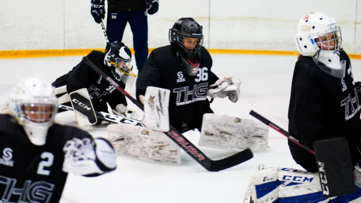 Travis Hoy Goaltending coach runs on-ice drills with young goalies in butterfly position during practice in Vernon, BC