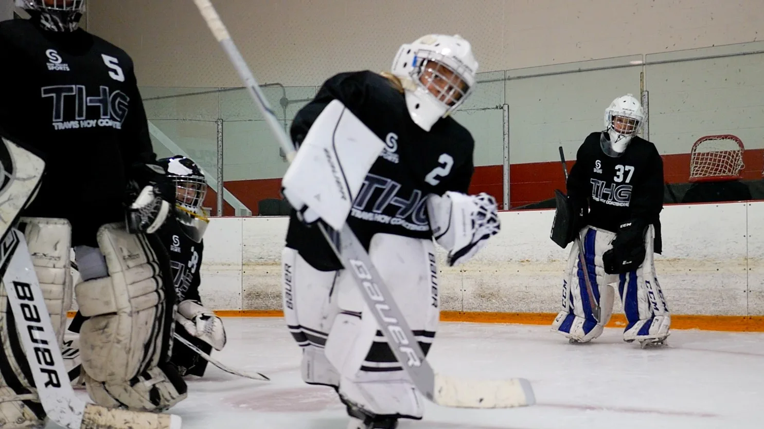 Travis Hoy instructs two young goalies during on-ice training at Travis Hoy Goaltending camp in Vernon, BC