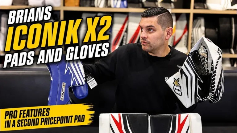 Reviewer holding Brian's ICONIK X2 goalie leg pads, glove, and blocker in a gear review setting