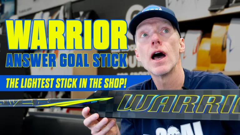 Reviewer holding Warrior Answer goalie stick with yellow-blue graphics, promoting it as lightest stick in shop